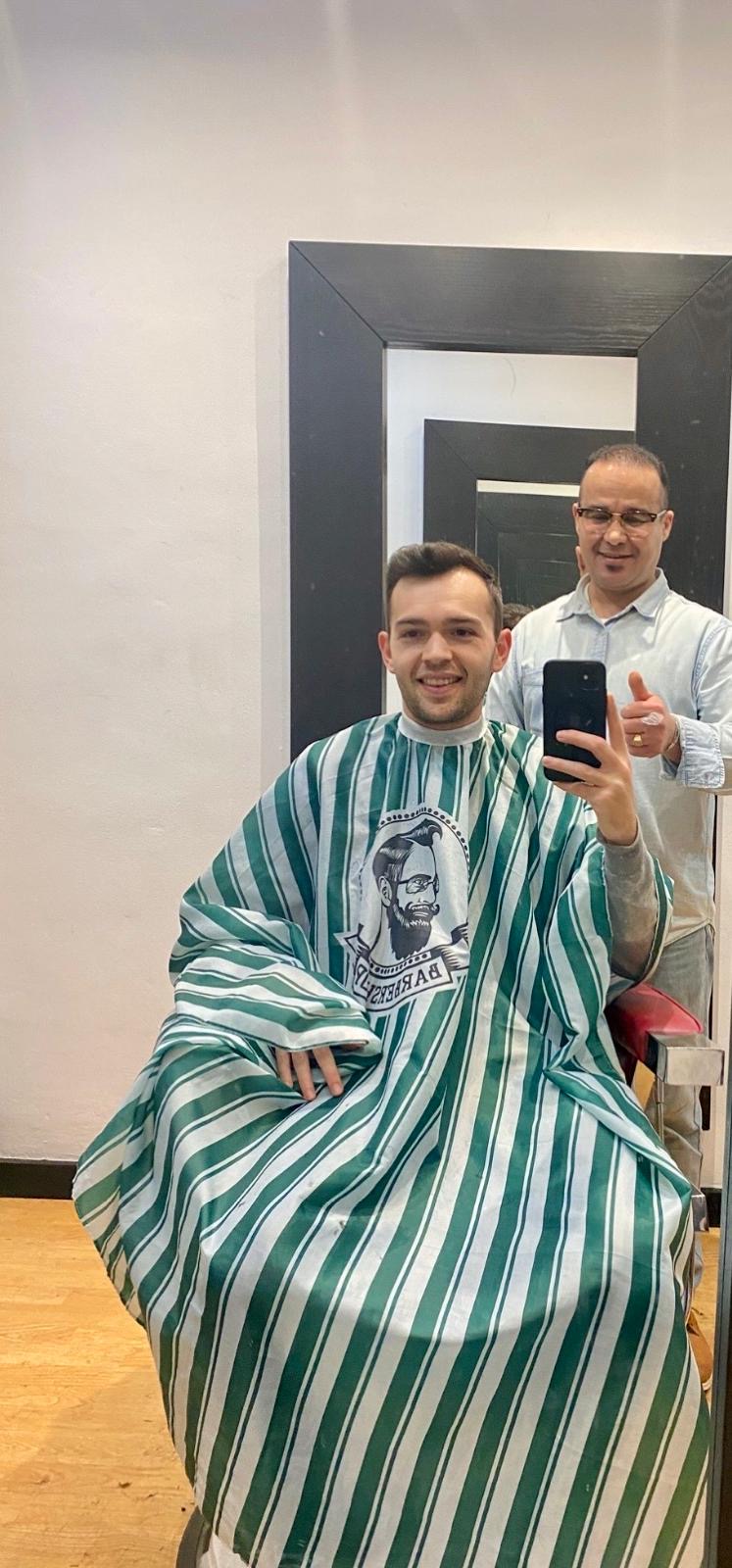 Cliente haciéndose un selfie en el espejo tras el corte