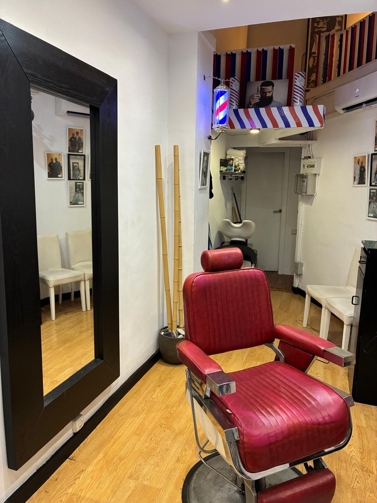 Sillón de barbería rojo en el interior del local