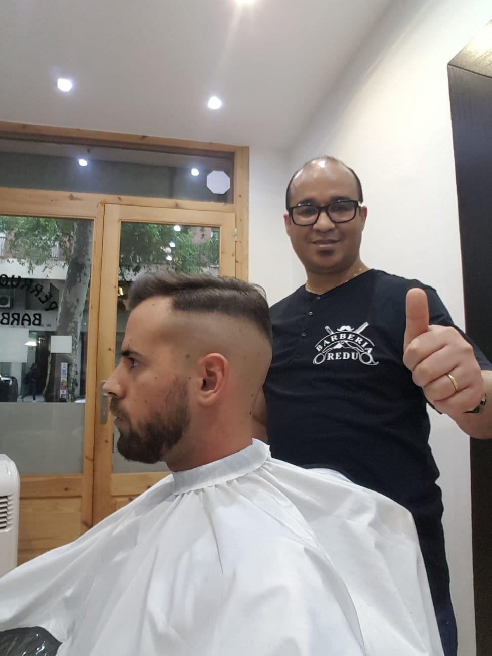Redu, el barbero, con un cliente en la silla de la barbería